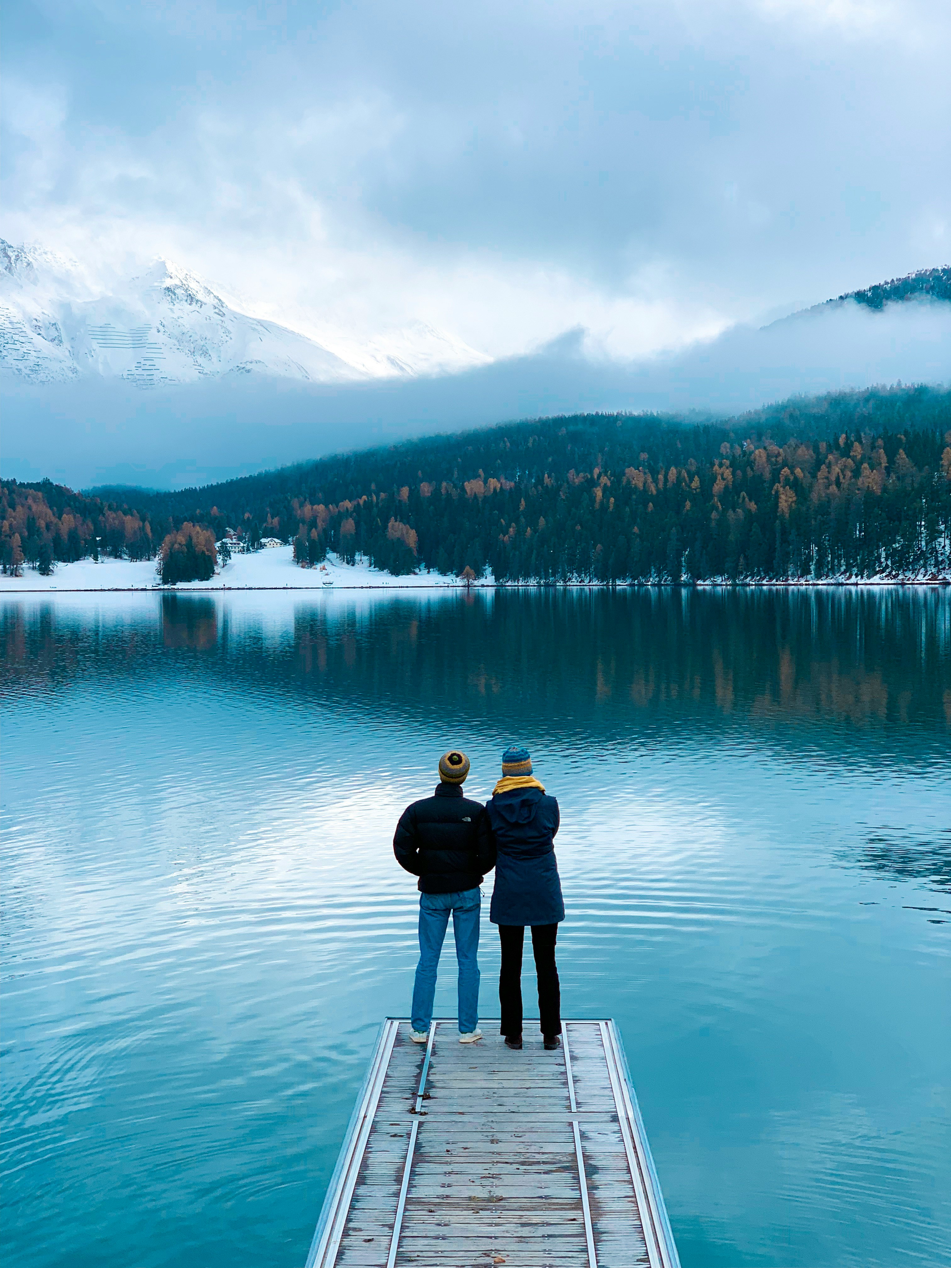 two persons standing on dock during daytime